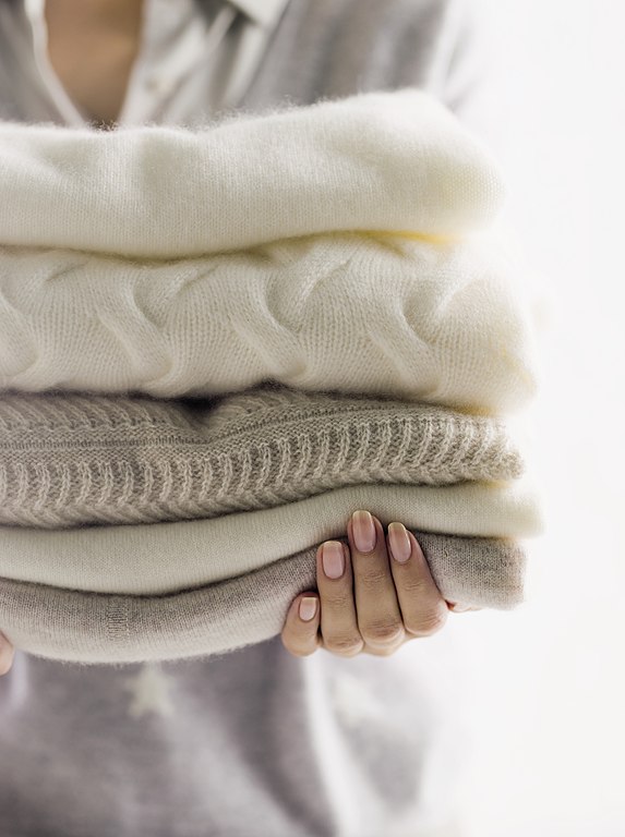 woman holding cashmere sweaters